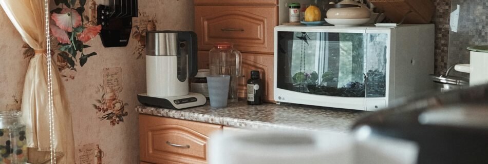 white microwave oven on brown wooden cabinet